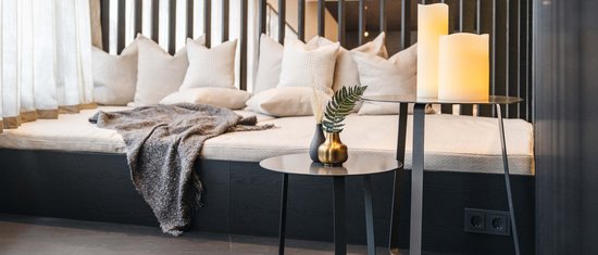 Your holidays on Arlberg in summer – a hiking paradise Cozy seating area with pillows, blanket, and tables with candles and vases