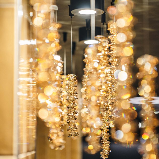 Goldfarbene, funkelnde Kronleuchter hängen von der Decke