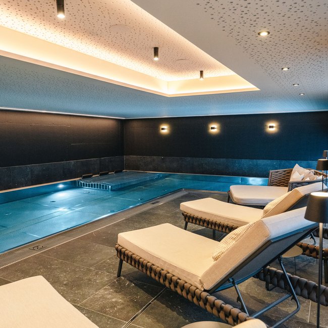 In St. Anton: Ihr Hotel mit Pool Moderner Innenpool mit Liegestühlen und spezieller Deckenbeleuchtung