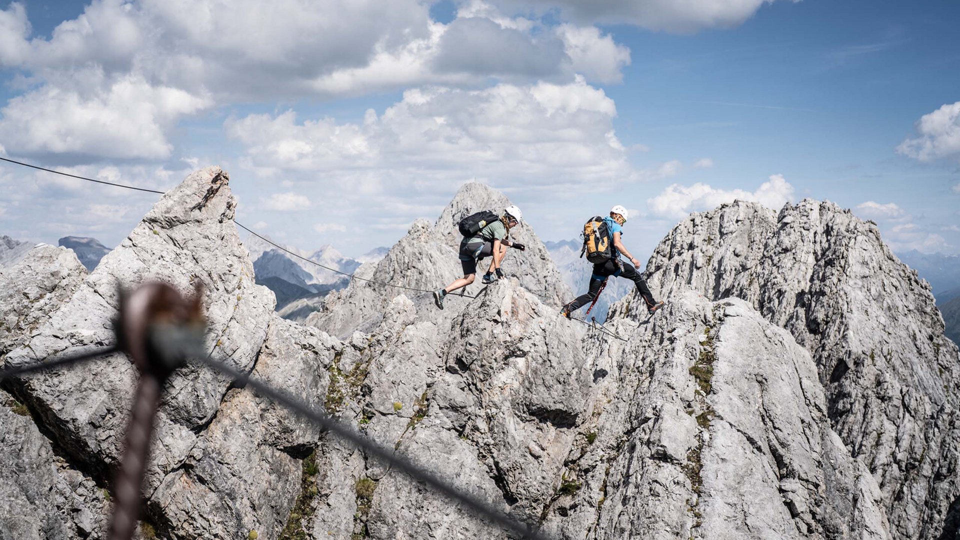 Zwei Kletterer wandern durch felsiges Gebirge bei klarem Himmel