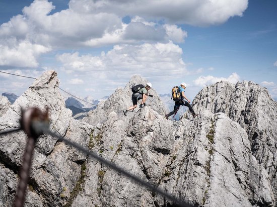 St. Anton: Sommerurlaub, Winterspaß Zwei Kletterer wandern durch felsiges Gebirge bei klarem Himmel
