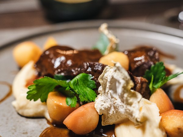 3 restaurants under one roof Elegant dish with meat, creamy sauce, potatoes, and fresh parsley on a plate