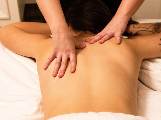 St. Anton: Sommerurlaub, Winterspaß Person erhält eine Rückenmassage auf einem Massagetisch mit weißem Handtuch