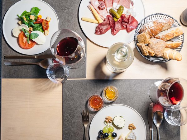 Table with antipasti, bread, red wine, and assorted appetizers