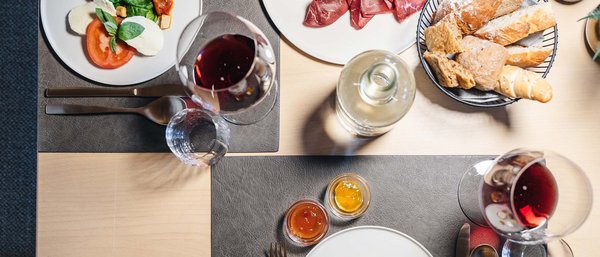 Table with antipasti, bread, red wine, and assorted appetizers