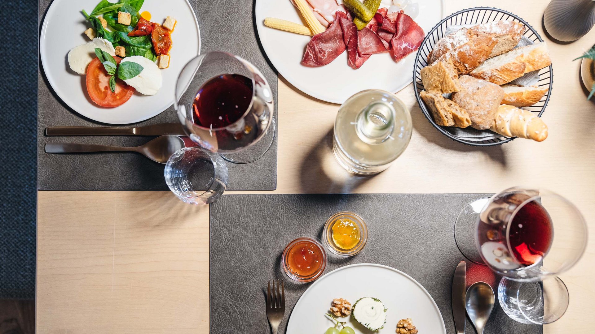 Table with antipasti, bread, red wine, and assorted appetizers