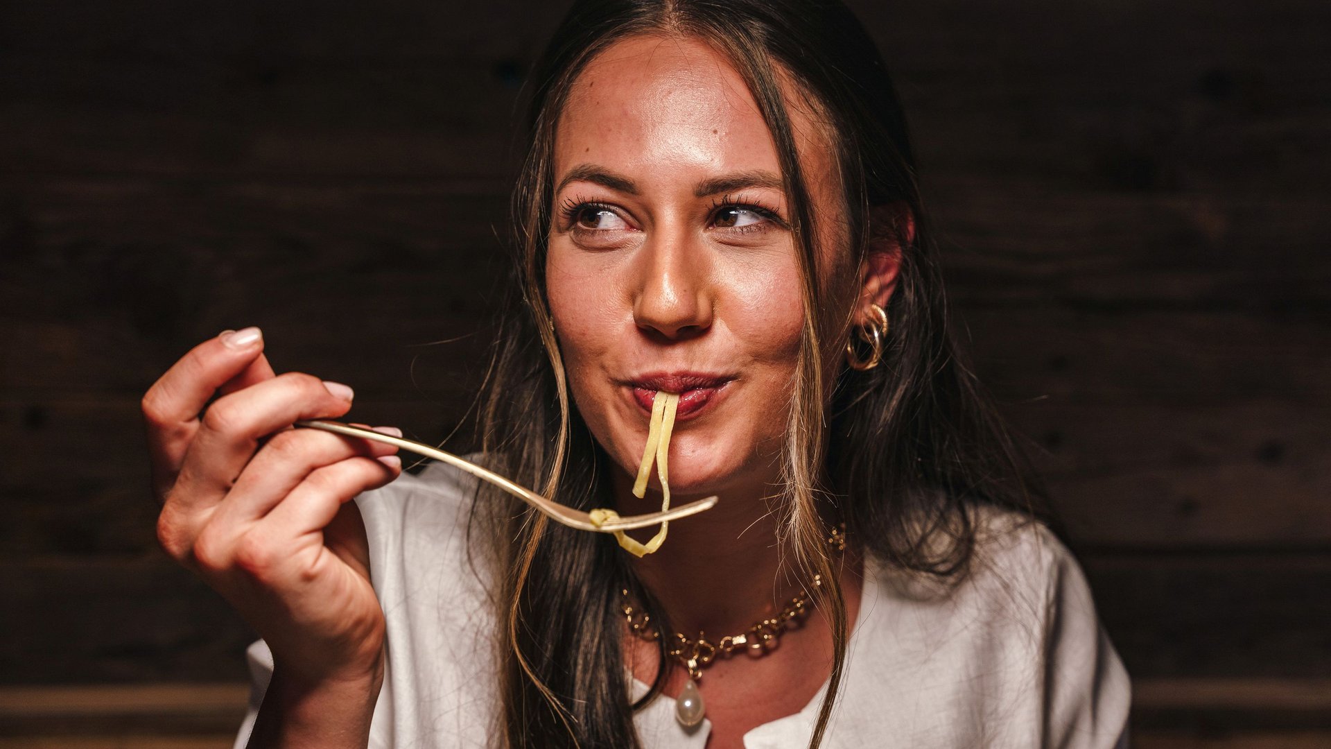Woman enjoying eating pasta with a fork