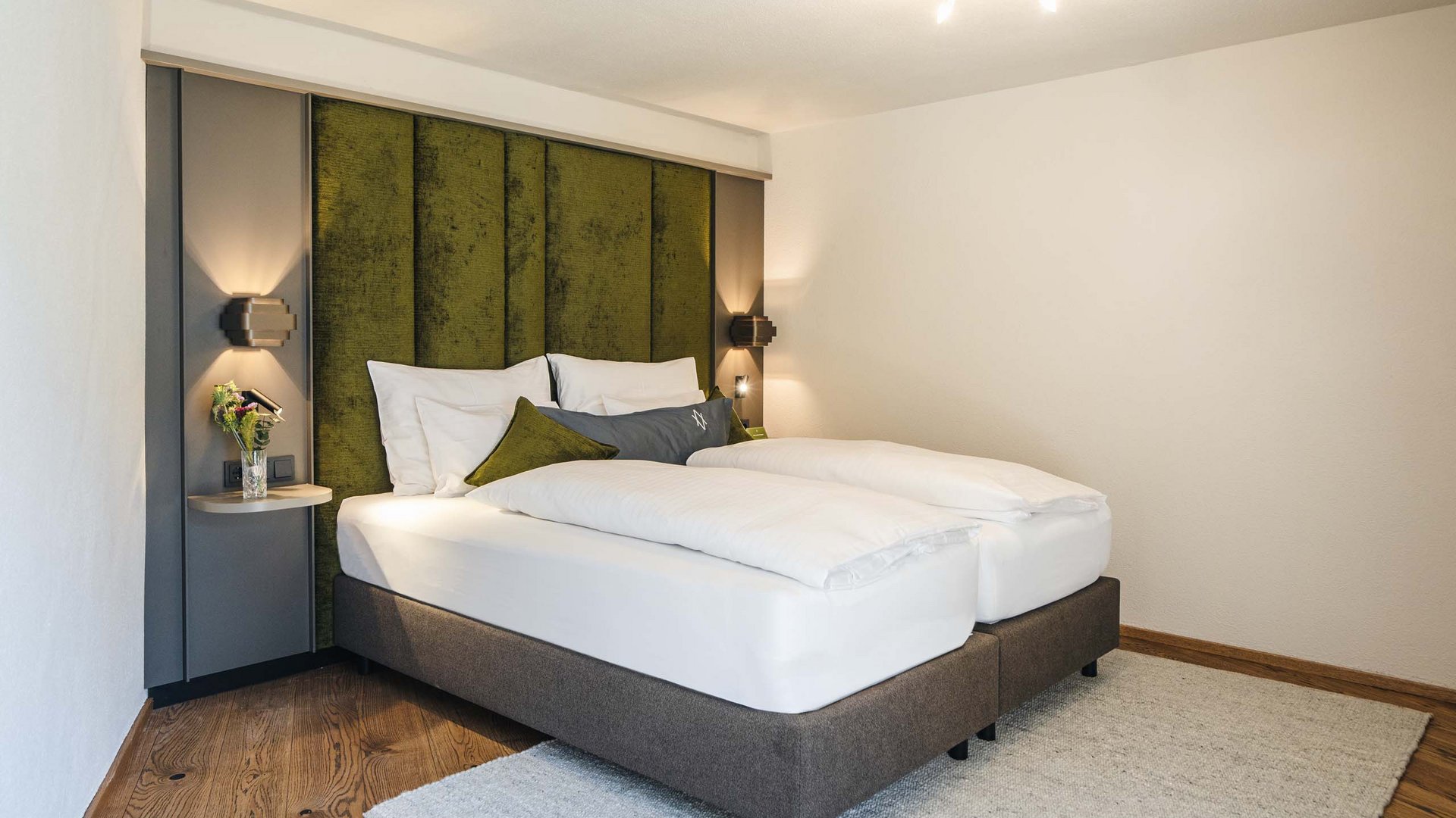 Modern bedroom with double bed and green padded headboard