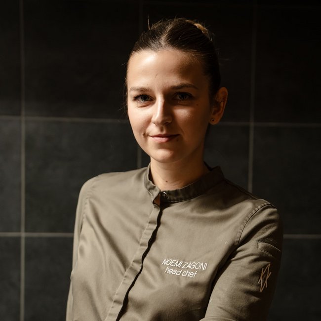 Chef presenting a plate with an artistically prepared dish