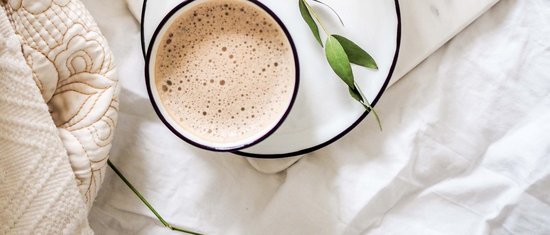 3 restaurants under one roof Cup of coffee on saucer with green leaves and white flowers on bedspread