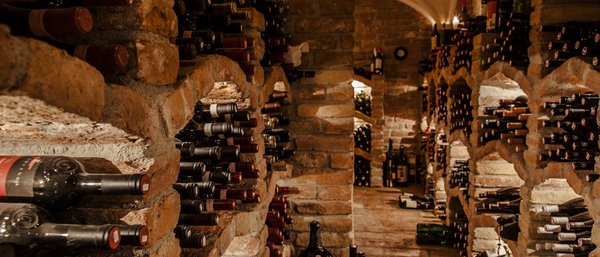 Wine cellar with many bottles stored in a brick cellar