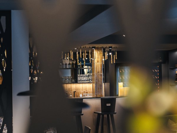 View through a lattice at a modern bar area with stools and lighting