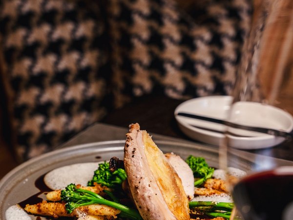 3 restaurants under one roof Gourmet dish with meat, broccoli, and sauce served on a plate