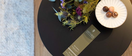 Ihr Urlaub am Arlberg im Sommer – das Wanderparadies Tisch mit Blumenstrauß, Karte und Schale mit Pralinen