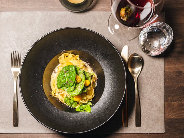 3 restaurants under one roof Pasta with fresh greens and yellow tomatoes, served with red wine and water