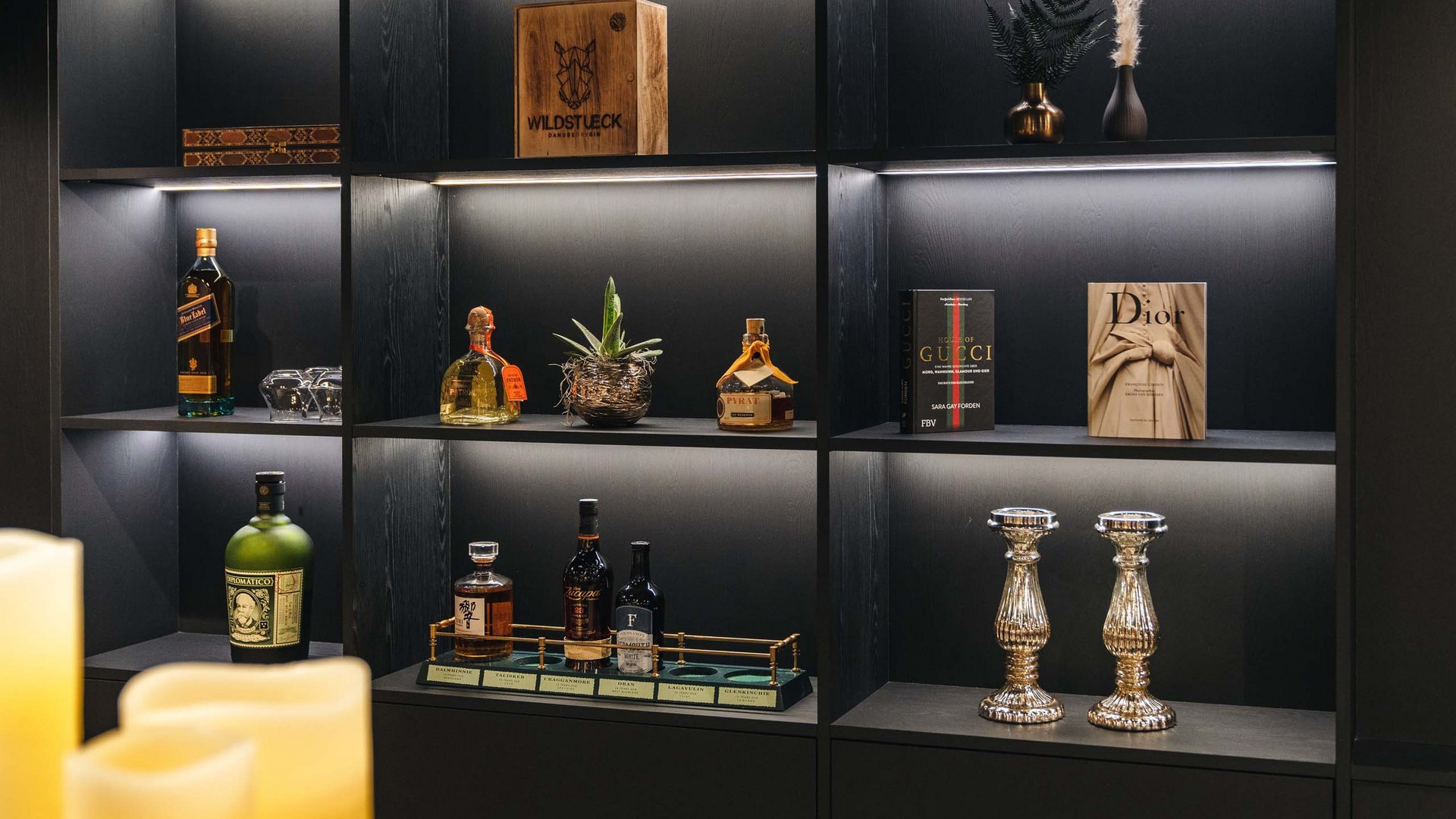 Cultural highlights around St. Anton am Arlberg Lit shelf with spirits, books, candles, and decorations in a modern room