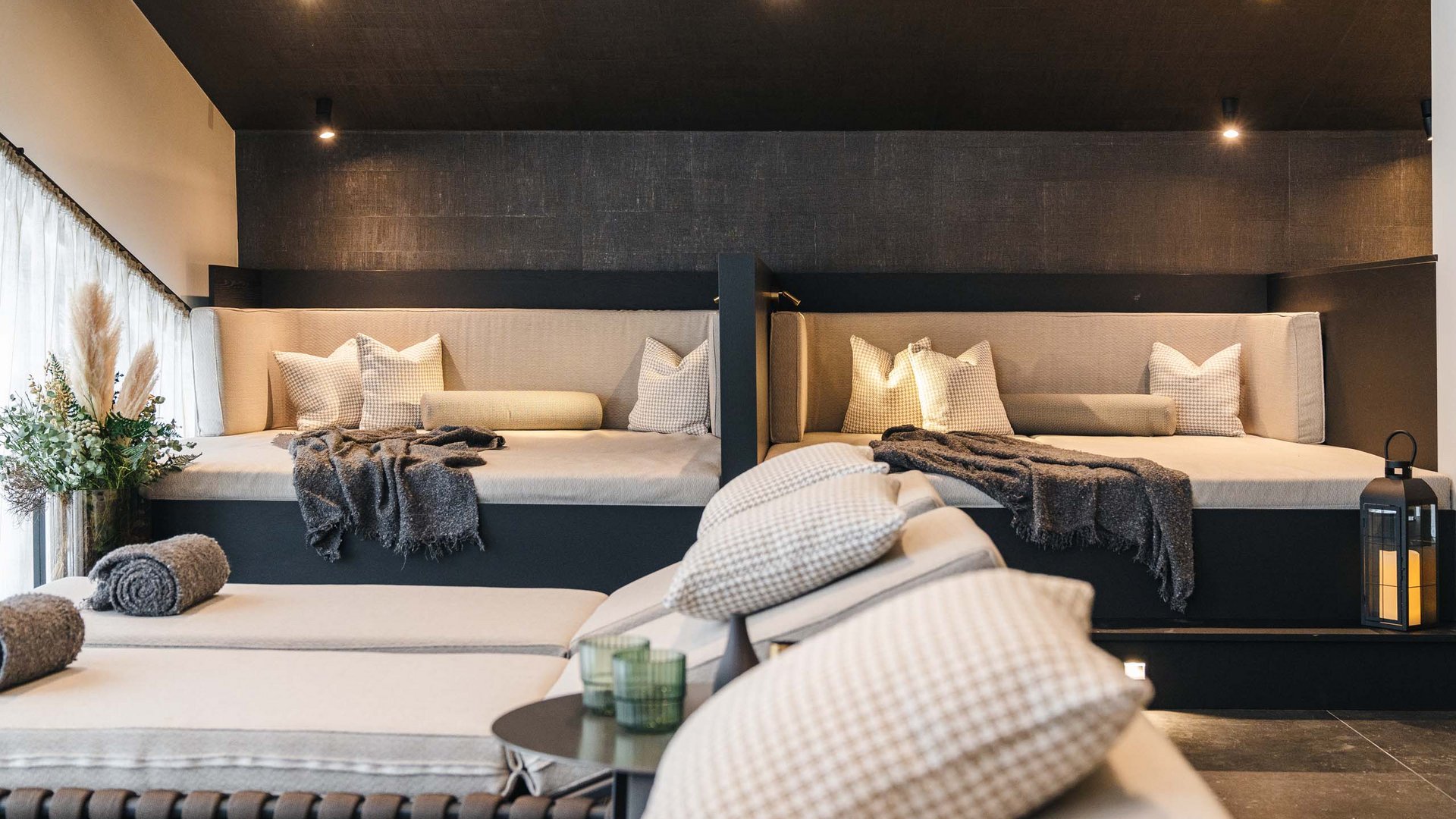 Cozy lounge area with beige seating and decorative pillows under soft lighting