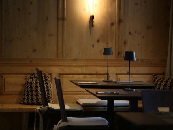 3 restaurants under one roof Cozy wooden corner with table lamps and cushioned chairs in restaurant