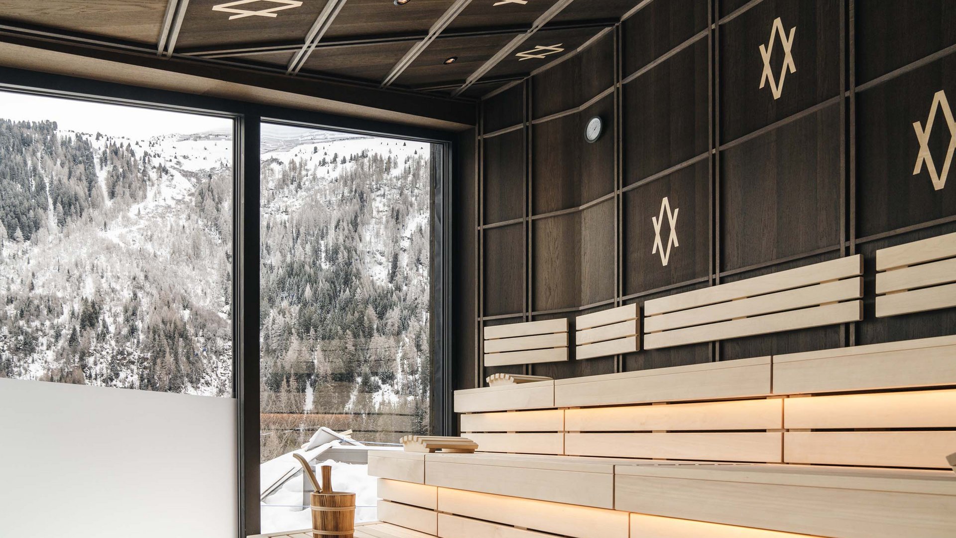 Modern sauna with view of snowy mountains through large window