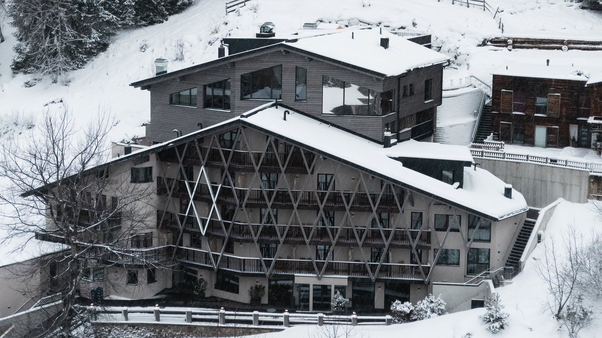 Snow-covered house in front of snow-covered pine forest in winter