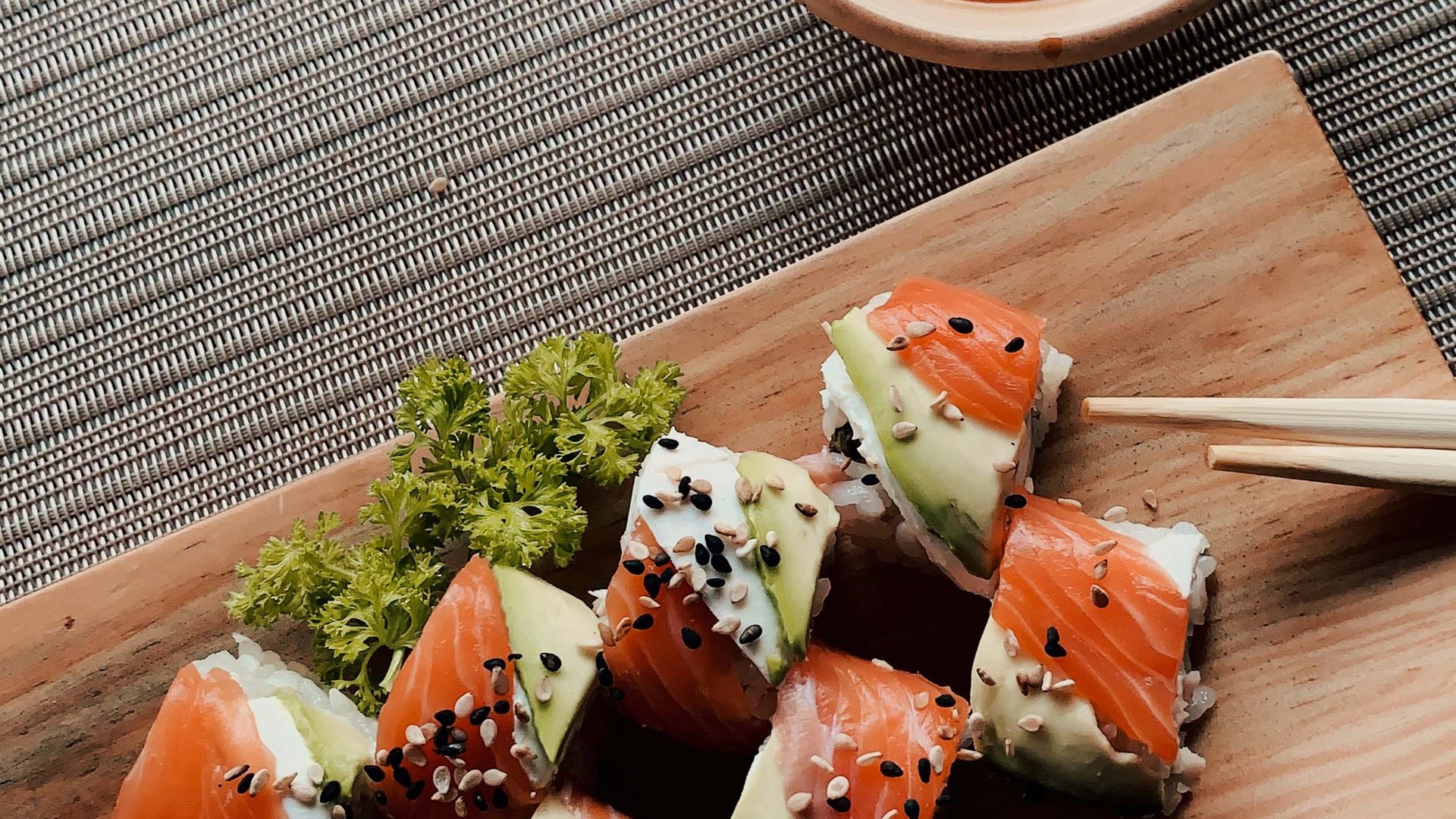 Salmon and avocado sushi on wooden board with soy sauce