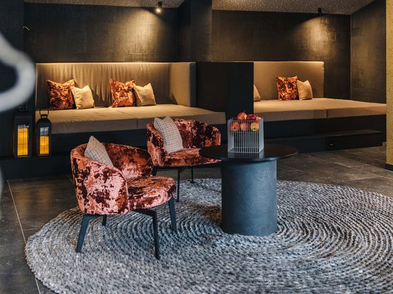Reine Urlaubsfreude in Ihrem Hotel in St. Anton Gemütlicher moderner Sitzbereich mit Samtstühlen und rundem Teppich