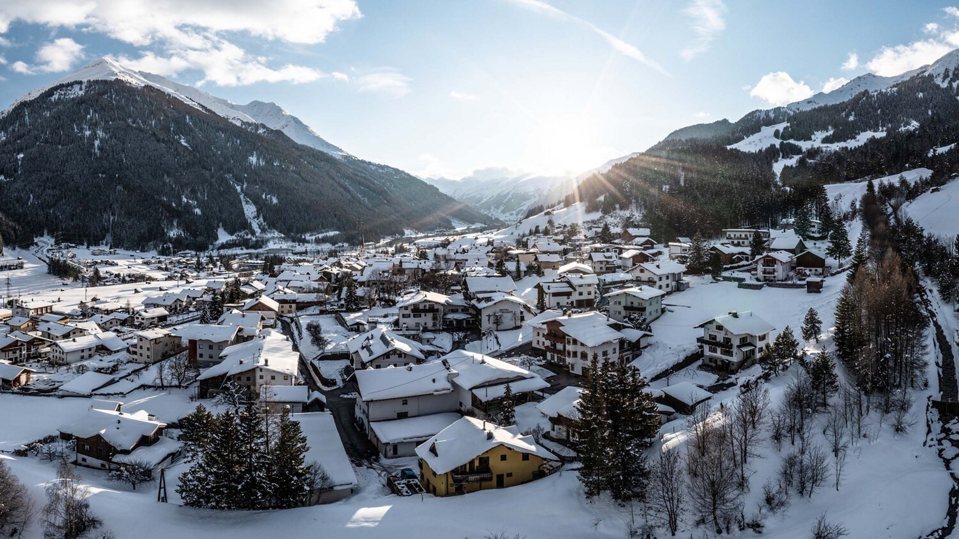 Sunrise over snow-covered mountain village in valley