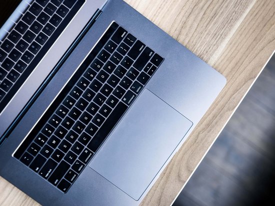 St. Anton: Sommerurlaub, Winterspaß Offener Laptop auf hellem Holzschreibtisch von oben fotografiert