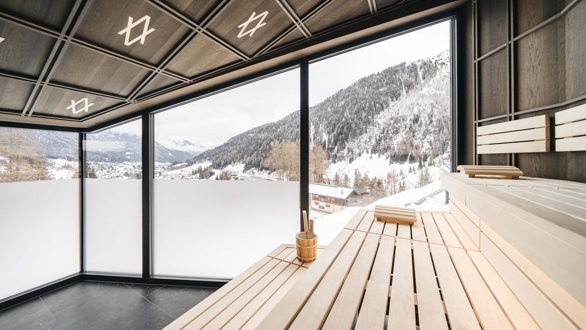 Interior of a sauna with panoramic view of snow-covered mountains
