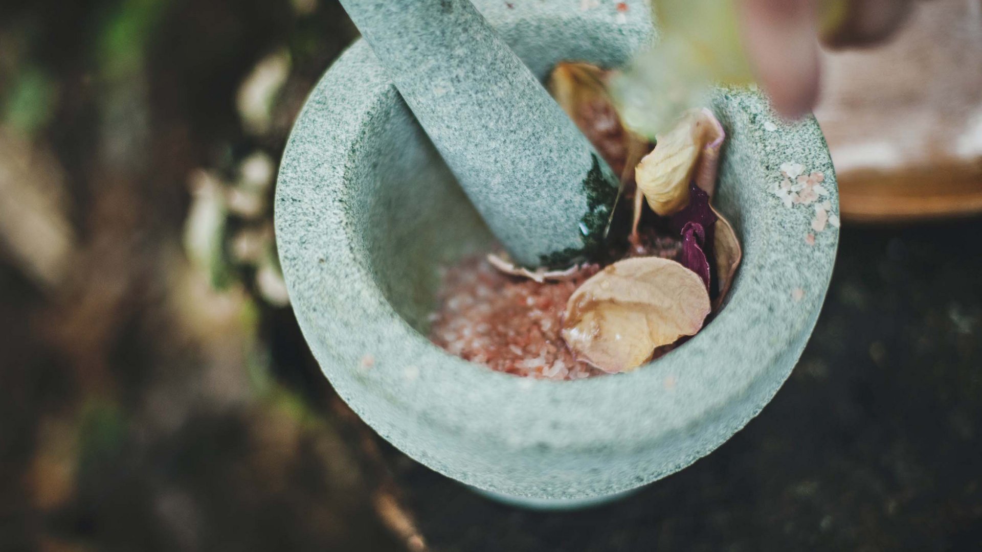 Mortar with pink salt and dried flower petals