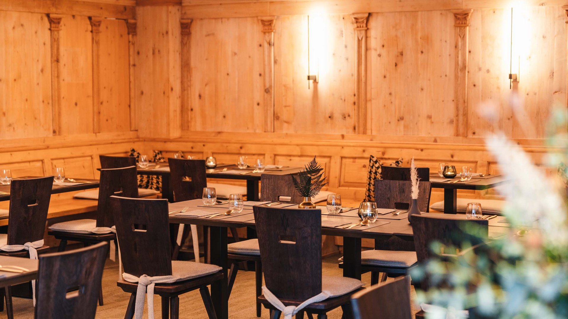 Cozy restaurant area with wooden walls and set dining tables