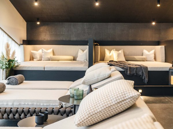 Modern living room with cozy seating areas, cushions, and decorative lamps