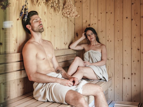 Man and woman relaxing in a wooden sauna