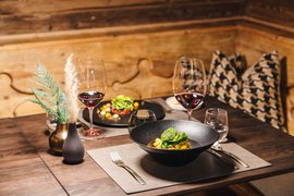 Elegantes Dinner mit Wein, Pasta und Dekoration auf Holztisch