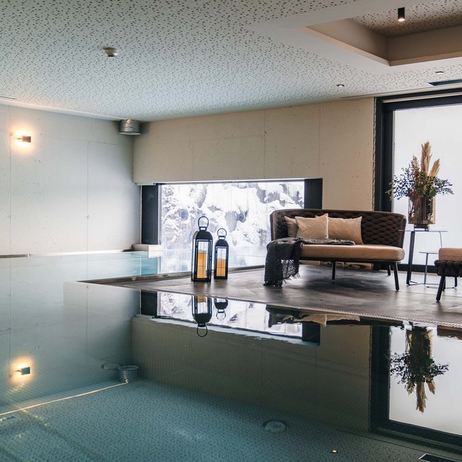 Moderner Innenpool mit Sitzbereich und großer Fensterfront