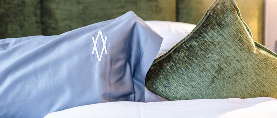 Ihr Urlaub am Arlberg im Sommer – das Wanderparadies Zwei Kissen auf einem Bett vor gepolstertem Kopfteil