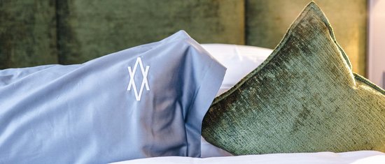 Zwei Kissen auf einem Bett vor gepolstertem Kopfteil