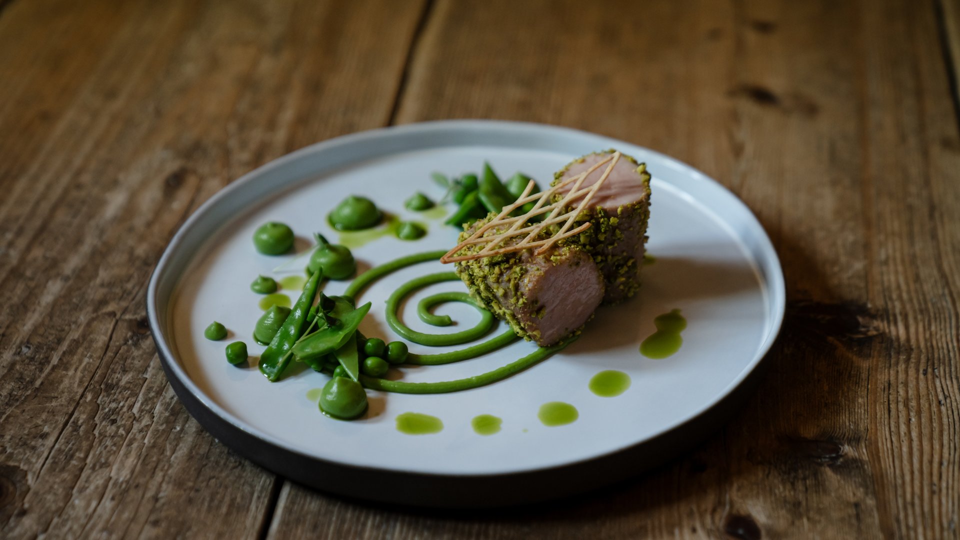 Garnierter Teller mit Pistazienfleisch und grünen Erbsen dekorativ angerichtet