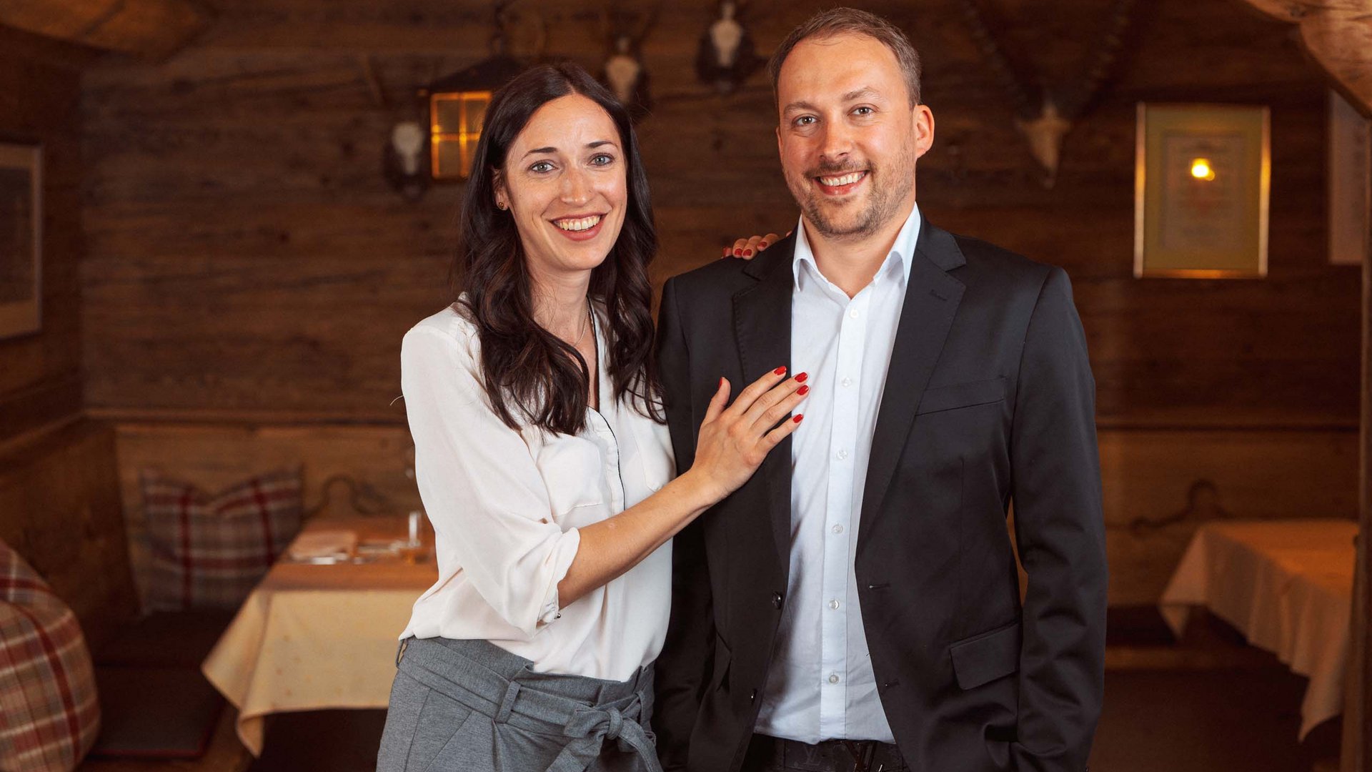Smiling couple dressed smartly in a rustic wooden restaurant
