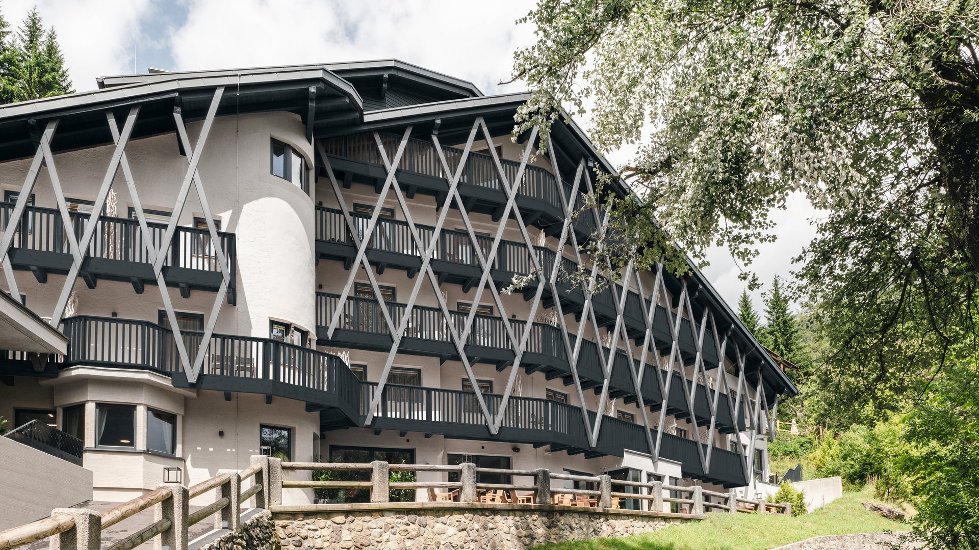 Traditionelles alpine Hotel mit Holzbalustraden und grüner Landschaft