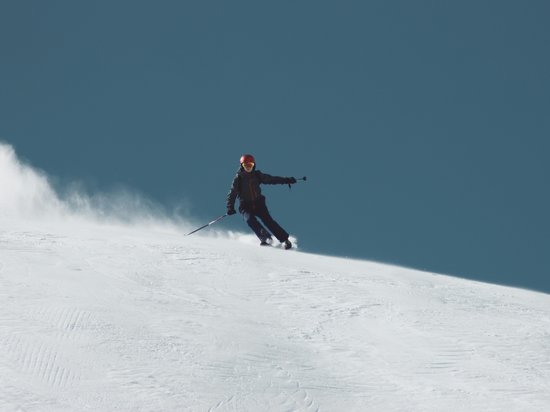 Our favourite time of year: the ski season Skier descending a snowy slope under clear sky