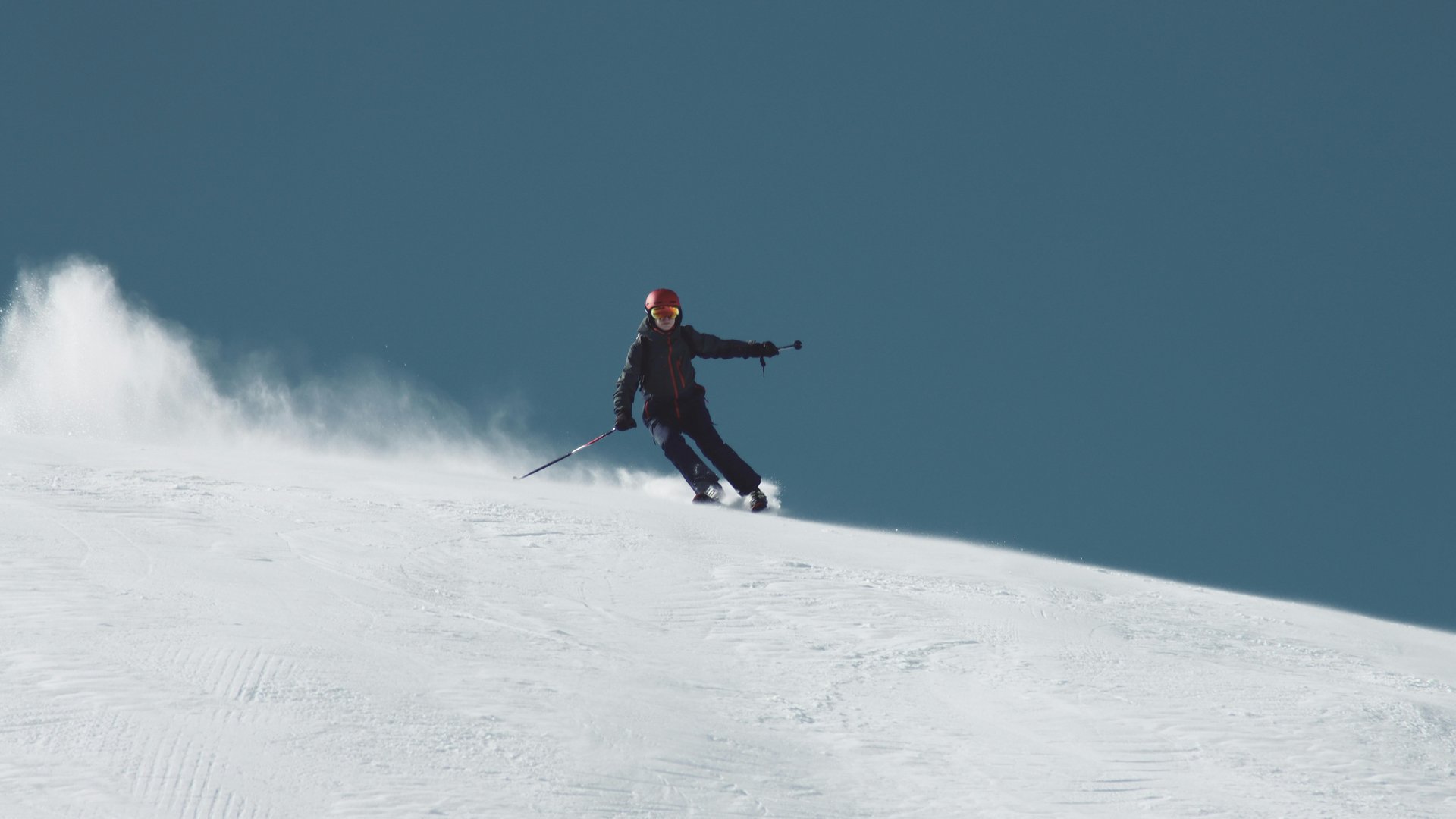 Well prepared for the ski season Skier descending a snowy slope under clear sky
